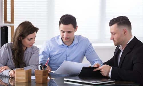 Couple Talking With Advisor During Meeting In Office